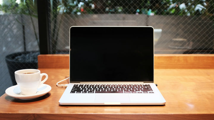 A laptop and coffee on a cafe table